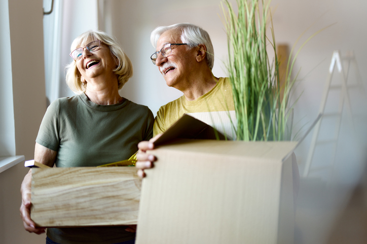 Happy mature couple packing their belongings before moving out of their apartment.