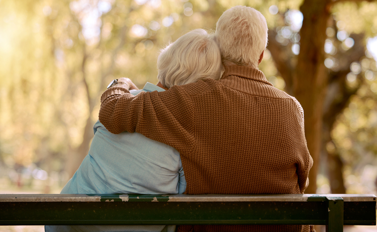 Senior man and senior woman sitting on a park bench